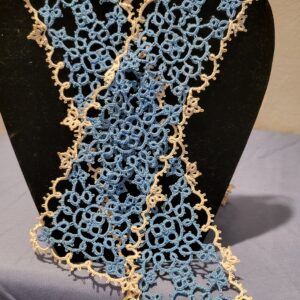 Long handmade blue and cream tatted lace scarf with intricate floral motifs and delicate picot edging displayed on a black bust stand.