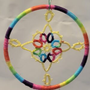 Hand-tatted yellow lace mandala displayed in a rainbow-wrapped circular hoop. The floral-inspired design features delicate symmetrical lacework with colorful accents and measures approximately 3.2 inches in diameter.