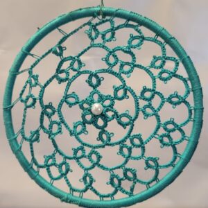 Hand-tatted seafoam teal mandala with intricate lacework and a pearl center suspended inside a matching wrapped 4-inch hoop.designs