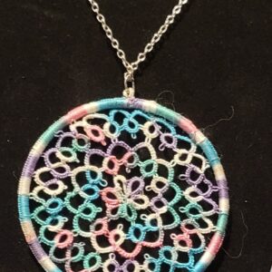 Round pastel hand-tatted lace medallion pendant in aqua, lavender, pink, and white on a 20-inch silver-tone chain displayed against a black background.