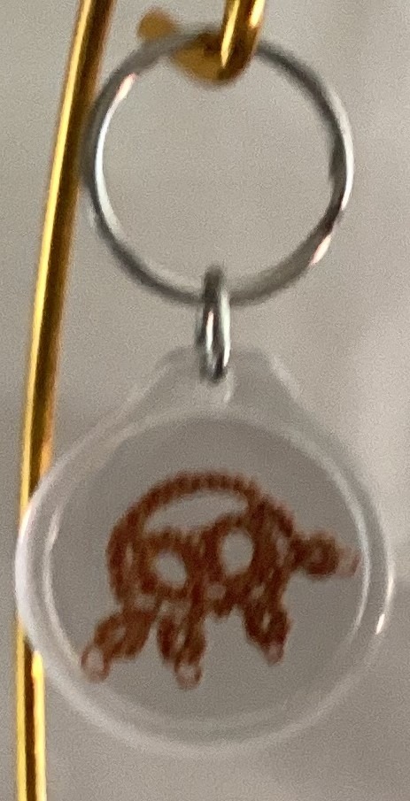 Clear acrylic keychain featuring a warm brown tatted turtle design with silver key ring.