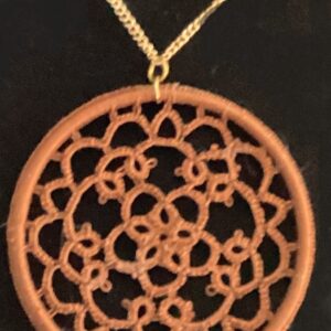 Round chestnut brown hand-tatted lace medallion pendant on a 20-inch chain displayed against a dark background.