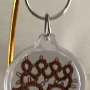 Clear acrylic keychain featuring a chestnut brown tatted paw print design with silver key ring.