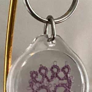 Clear acrylic keychain featuring a lavender tatted paw print design with silver key ring.
