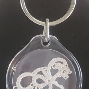 Clear acrylic keychain featuring a delicate white tatted bird design with silver key ring.
