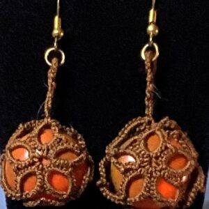 Handmade brown tatted earrings with amber-orange cabochons and gold-tone hooks against a black background.