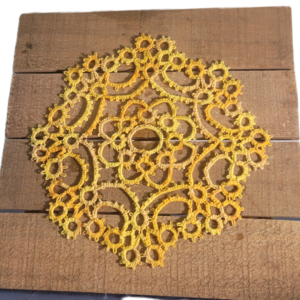 Handmade golden yellow needle-tatted lace doily with intricate floral and circular motifs in an 8-inch square design, displayed on a rustic wooden background.