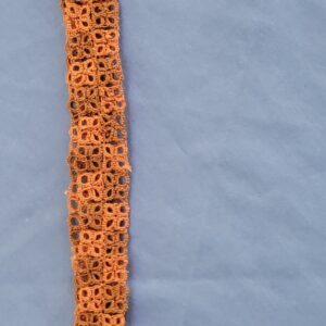 Rust-orange hand-tatted lace hat band displayed around a neutral-colored wide-brim hat outdoors