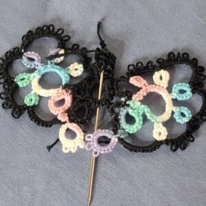 Hand-tatted butterfly hat and lapel pin with black lace wings accented by pastel mint, aqua, pink, lavender, and cream thread.