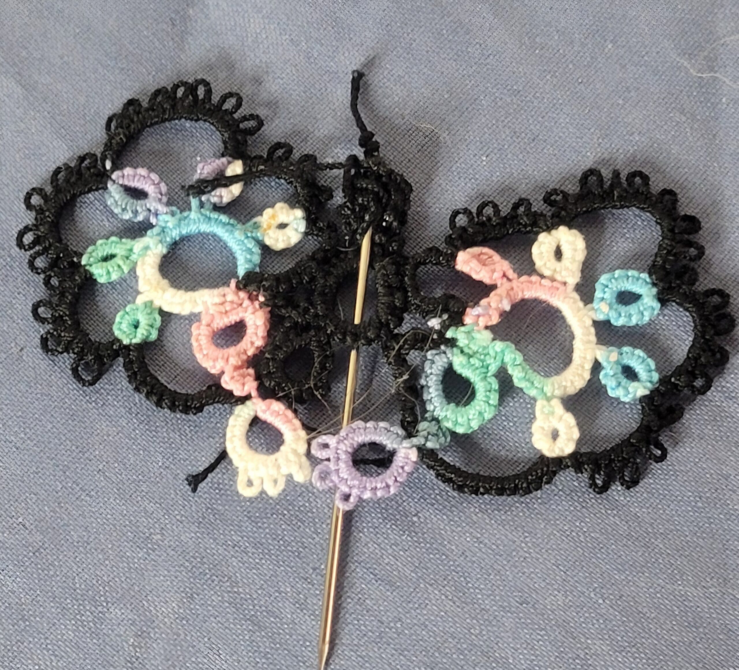 Hand-tatted butterfly hat and lapel pin with black lace wings accented by pastel mint, aqua, pink, lavender, and cream thread.
