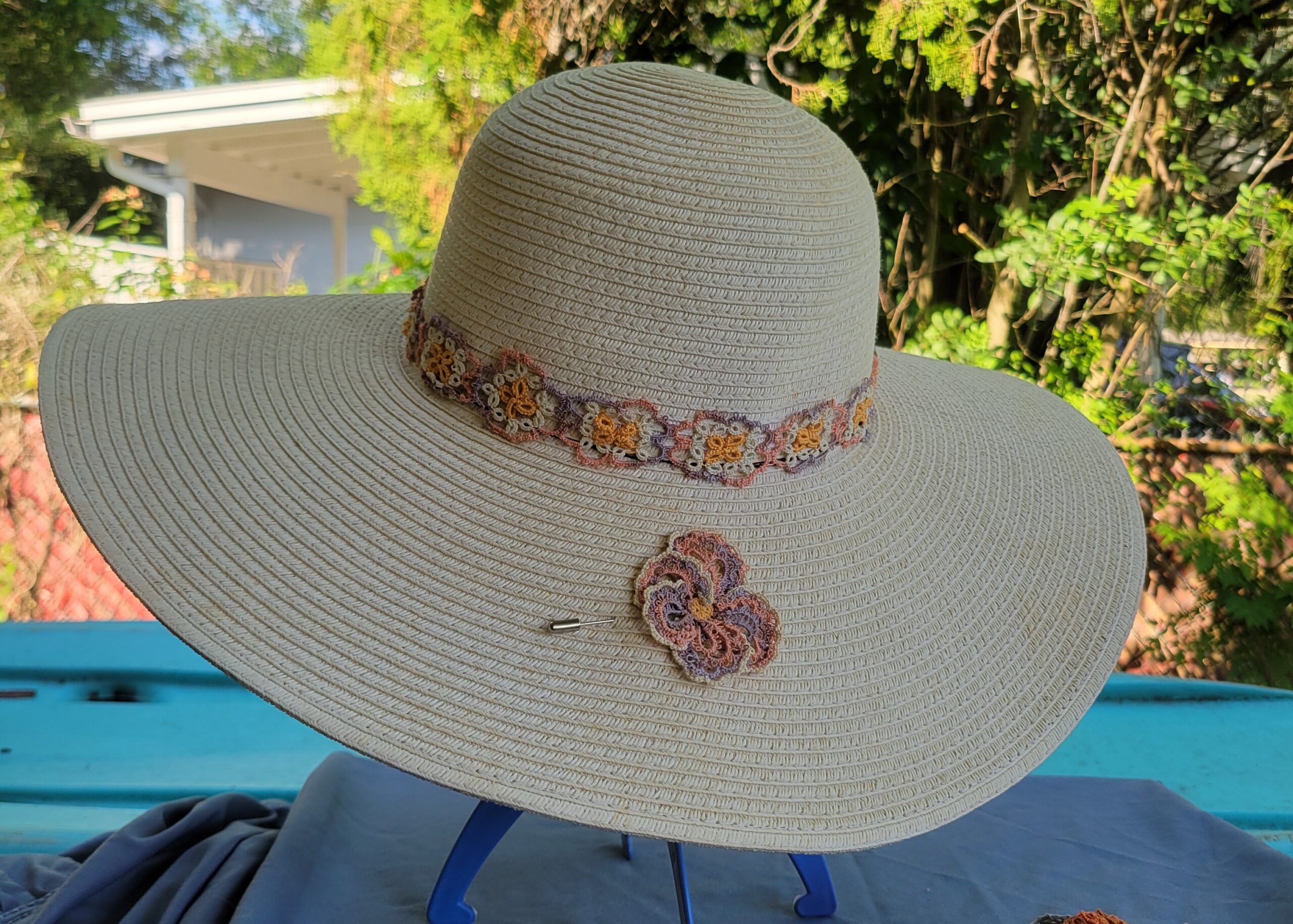 Autumn-inspired hand-tatted floral hat and lapel pin with coordinating lace hat band displayed on a neutral wide-brim hat; hat not included