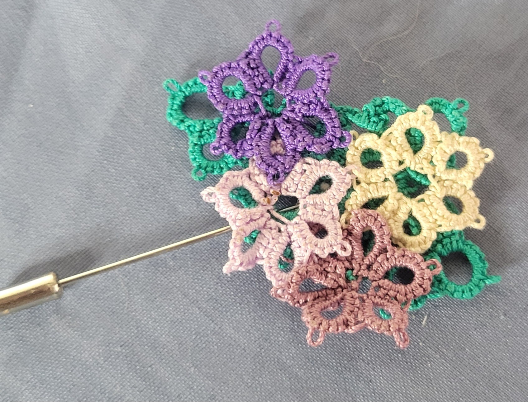 Hand-tatted Wildflower Meadow hat and lapel pin with layered purple, pink, green, cream, and brown flowers