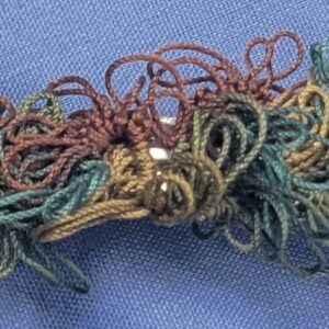 Rustic hand-tatted lace barrette with layered floral motifs in forest green, olive, brown, copper, and muted gold, approximately 2.75 inches long.