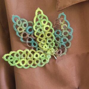 Summer Garden hand-tatted hat and lapel pin featuring layered lime green, aqua, and taupe leaf motifs