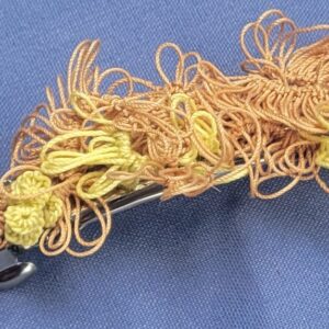 Sunlit Meadow hand-tatted lace barrette in tan, golden brown, and yellow-green with intricate floral and leafy motifs, approximately 1.75 inches long.