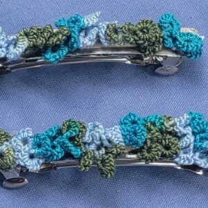 Set of two hand-tatted floral lace barrettes in teal, blue, pale blue, and sage green, each measuring approximately 2.75 inches long.